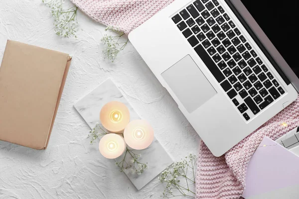 Velas ardientes, flores y portátil en la mesa — Foto de Stock