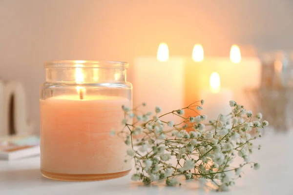 Beautiful burning candle and flowers on table — Stock Photo, Image