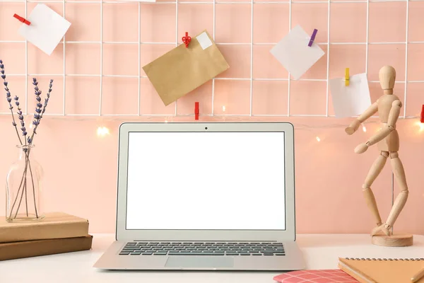 Comfortable workplace with laptop near color wall — Stock Photo, Image