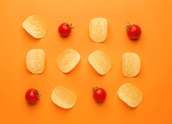 Savoureux chips de pommes de terre et tomates sur fond de couleur — Photo
