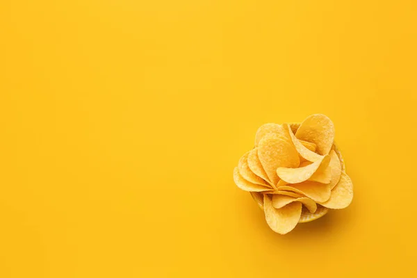 Bowl with tasty potato chips on color background — Stock Photo, Image