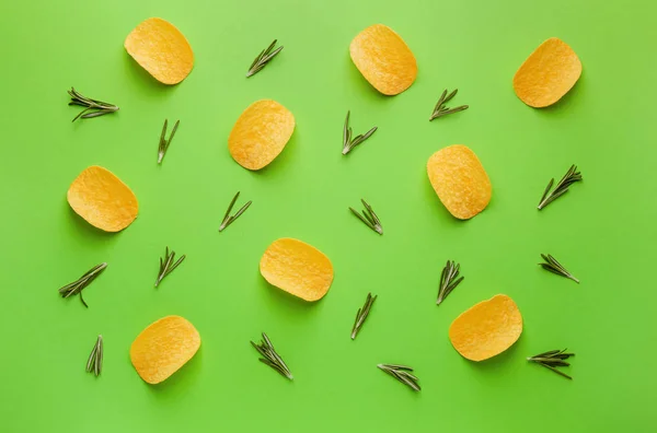 Tasty potato chips and herbs on color background — Stock Photo, Image
