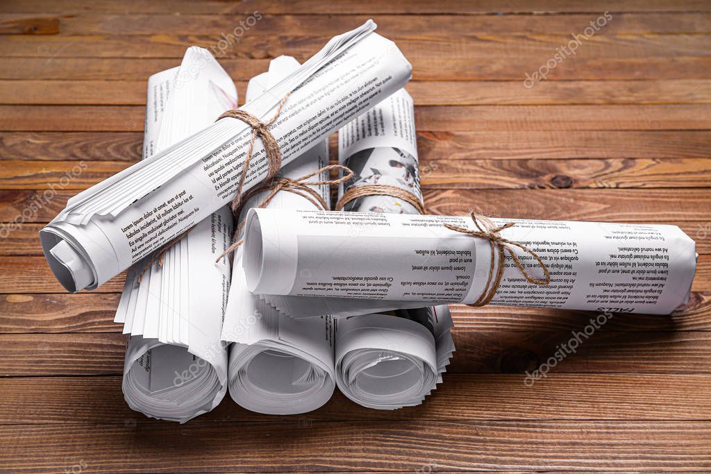 Many newspapers on wooden background