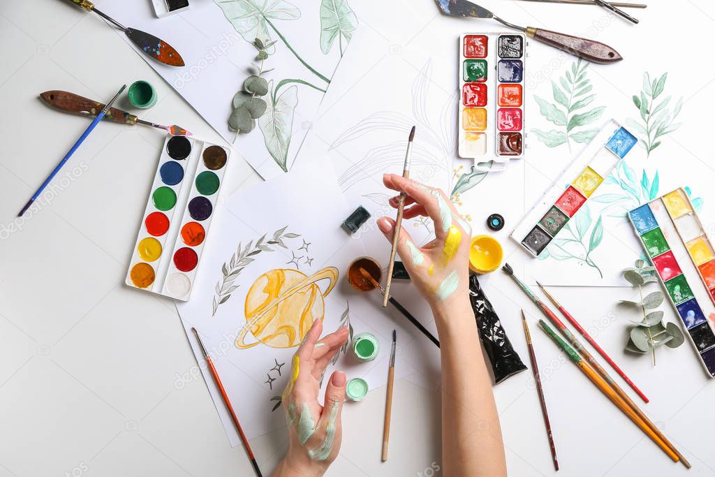 Artist painting picture at table