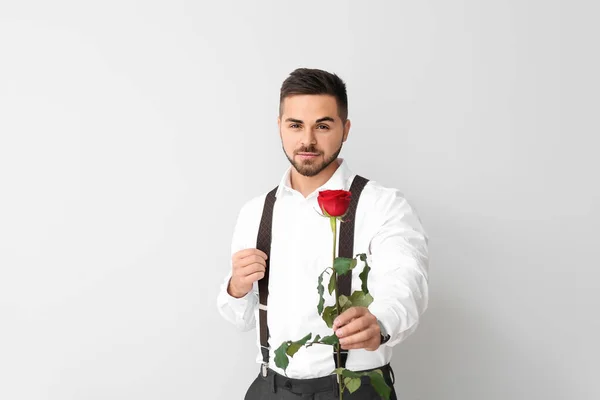 Hombre guapo con flor sobre fondo claro. Celebración de San Valentín —  Fotos de Stock