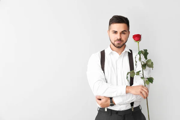 Handsome man with flower on light background. Valentine's Day celebration — Stock Photo, Image