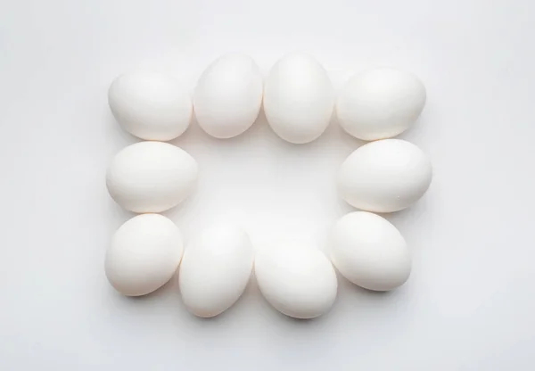 Cadre fait d'œufs crus frais sur fond blanc — Photo