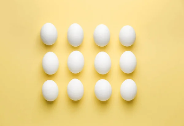 Uova fresche crude su sfondo di colore — Foto Stock