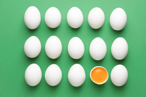 Broken egg among whole ones on color background. Concept of uniqueness — Stock Photo, Image