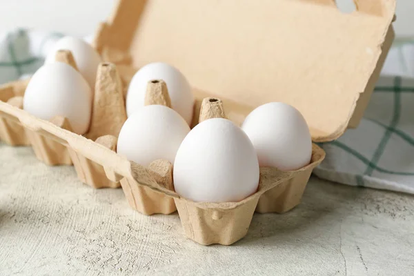 Schachtel mit frischen rohen Eiern auf dem Tisch — Stockfoto