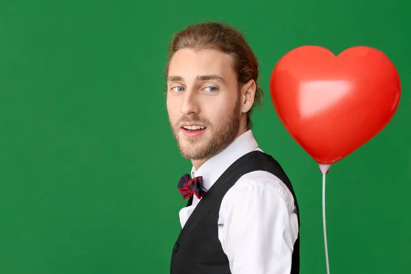 Jóképű férfi szív alakú lufival, színes háttérrel. Valentin-napi ünneplés — Stock Fotó