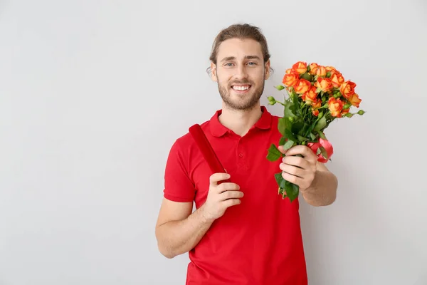 꽃 과 선물을 배경으로 한 잘생긴 남자. 발렌타인데이 — 스톡 사진