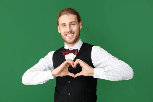 Bel homme montrant coeur avec les mains sur fond de couleur. Fête de la Saint-Valentin — Photo