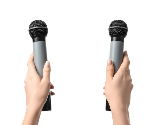 Manos femeninas con micrófonos sobre fondo blanco — Foto de Stock