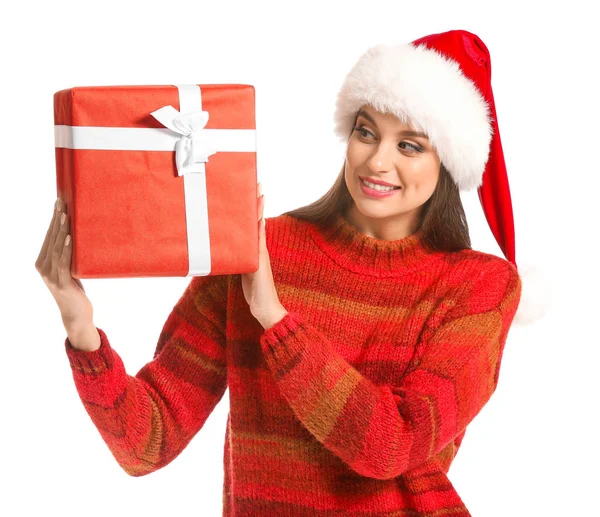 Beautiful young woman in Santa hat and with Christmas gift on white background — Stock Photo, Image