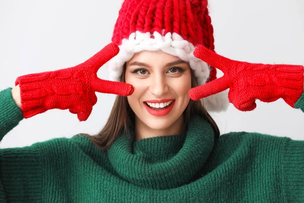 Vacker ung kvinna i Santa hatt på ljus bakgrund — Stockfoto