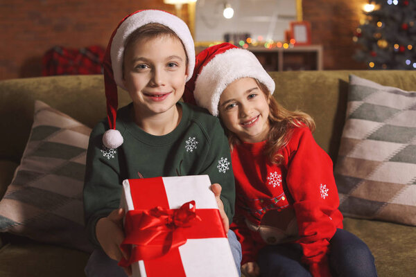 Little children with Christmas gift at home