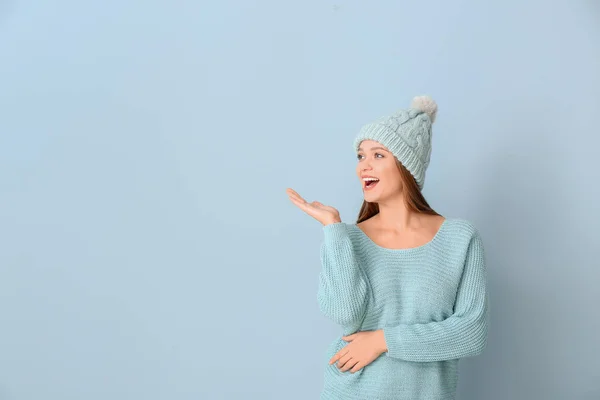 Mooie vrouw in de winter kleren op kleur achtergrond — Stockfoto
