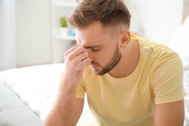 Genç adam evde baş ağrısı çekiyor.