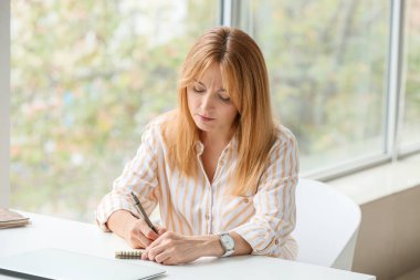 Ofiste çalışan güzel olgun bir kadın.