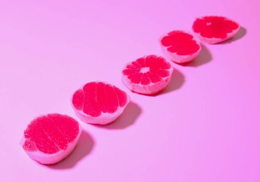 Renkli arkaplanda taze kesilmiş greyfurt