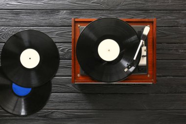 Koyu ahşap arka planda vinil diskleri olan kayıt çalar
