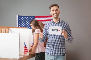 Elinde Usa oy kullanma merkezinde seçtiğim metni olan genç adam.