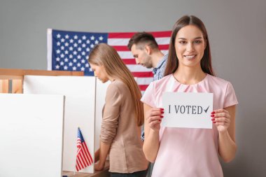 Usa oy kullanma merkezinde seçtiğim metinle elinde kağıt tutan genç bir kadın.