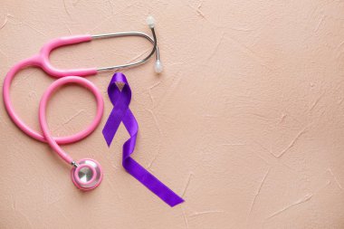 Dünya Kanser Günü sembolü olarak mor kurdele ve renk arkaplan üzerinde steteskop