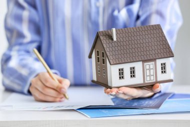 Masada ev modeli olan bir emlakçı, yakın plan.