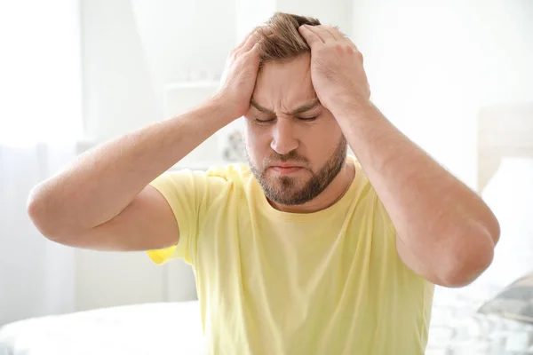 Young man suffering from headache at home — Stock Photo, Image