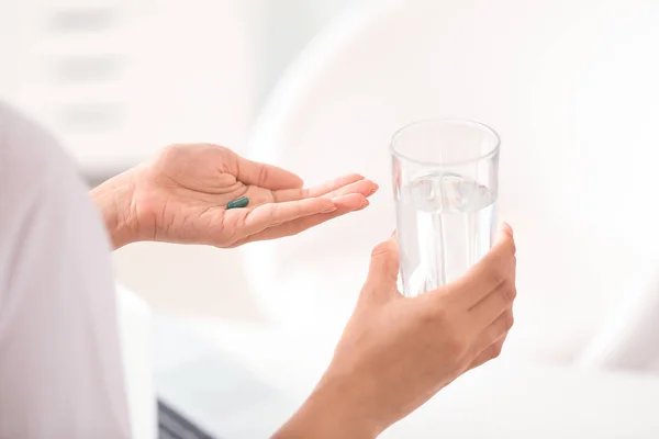 Doctor taking pill in clinic — Stock Photo, Image