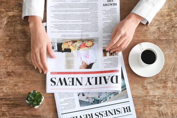 Young woman reading newspaper at table — Stock Photo, Image