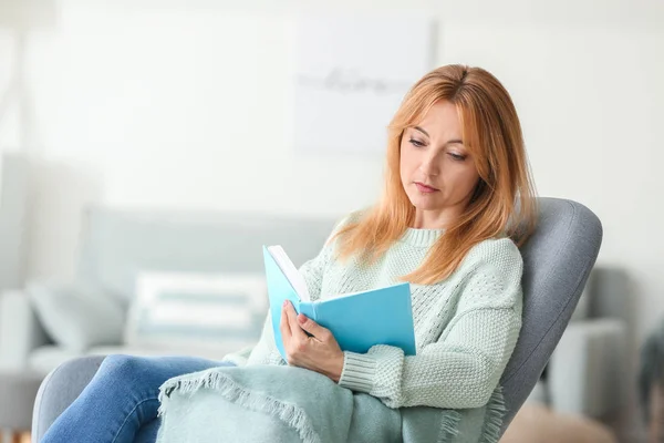 Belle femme mature lecture livre à la maison — Photo