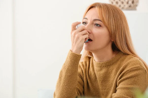 Schöne reife Frau mit Asthma-Inhalator zu Hause — Stockfoto