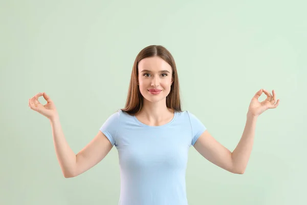 Schöne Frau meditiert auf hellem Hintergrund — Stockfoto