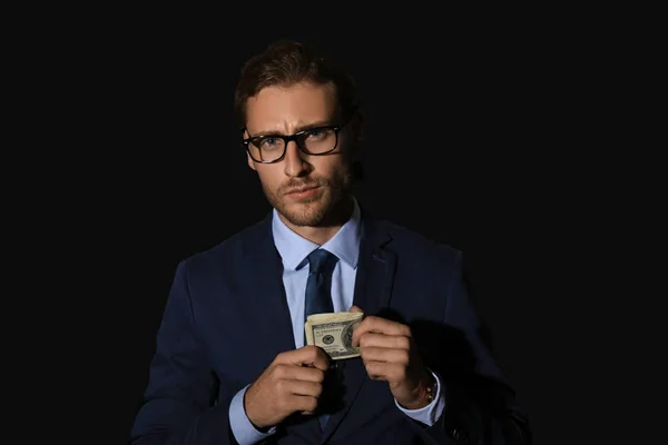Retrato de hombre de negocios guapo con dinero sobre fondo oscuro — Foto de Stock