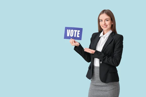 Молодая предпринимательница держит бумагу с текстом VOTE на цветном фоне — стоковое фото