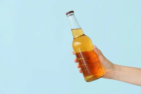 Ruka s lahví piva na barevném pozadí — Stock fotografie