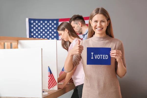 Young woman holding paper with text I VOTED at USA polling station — Stock Photo, Image