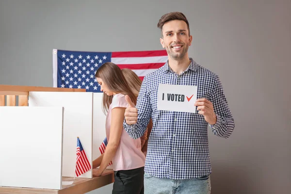 Jovem segurando papel com texto I VOTED na estação de votação dos EUA — Fotografia de Stock