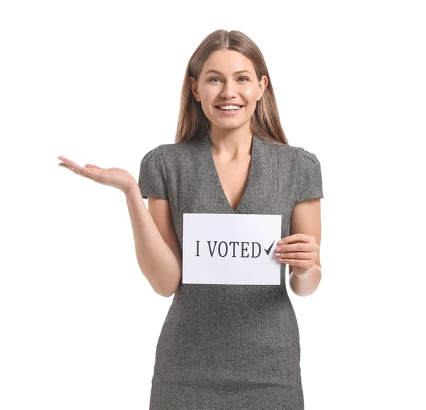 Young woman holding paper with text I VOTED on white background — Stock Photo, Image