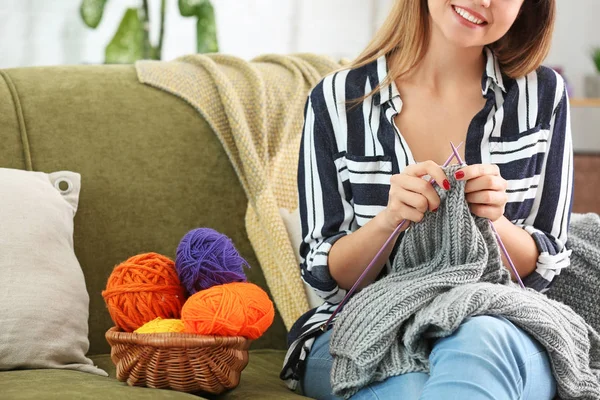Mladá žena pletení svetru doma — Stock fotografie