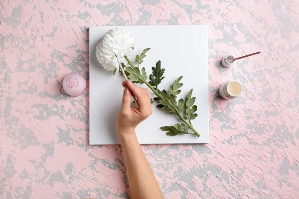 Renkli arkaplanda fırçası olan ressamın tuval, çiçek ve eli — Stok fotoğraf
