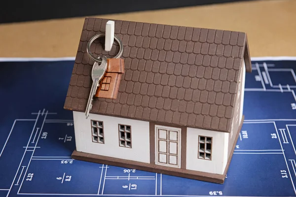 Modelo de casa con llave y dibujo sobre mesa. Concepto de compra de una propiedad nueva —  Fotos de Stock