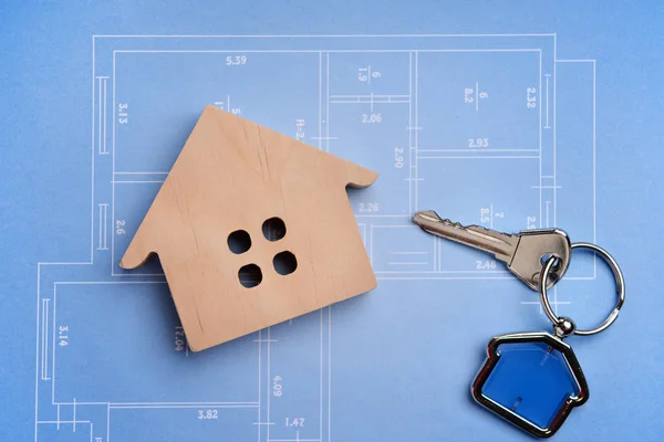 Figure of house and key on drawing. Concept of buying new property — Stock Photo, Image