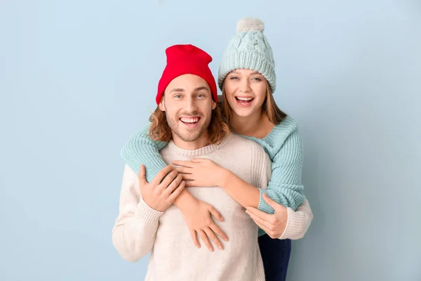 Pareja feliz en ropa de invierno sobre fondo de color — Foto de Stock