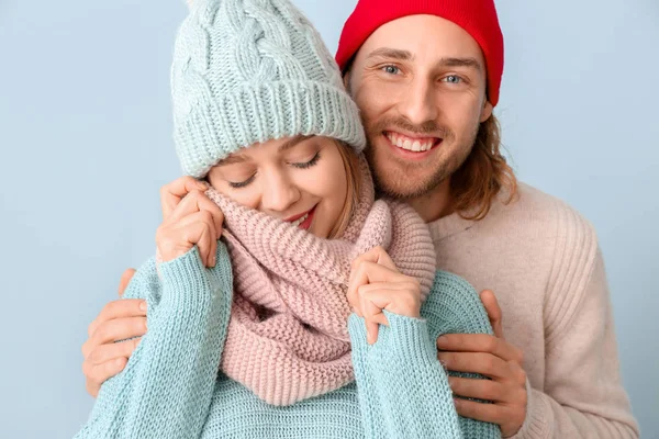 Щаслива пара в зимовому одязі на кольоровому фоні — стокове фото