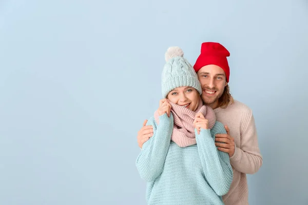 Happy couple in winter clothes on color background — Stock Photo, Image
