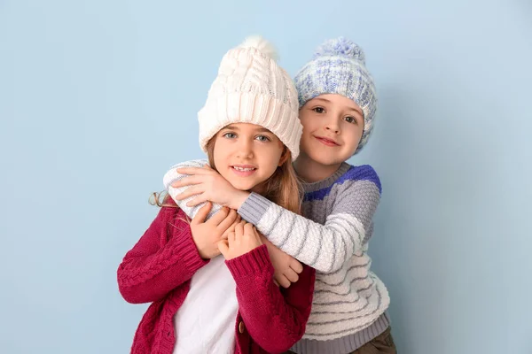Crianças bonitos em roupas de inverno no fundo de cor — Fotografia de Stock